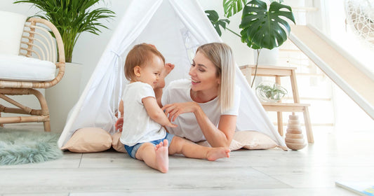 Mom and baby playing and relaxing in a cozy room with eco-friendly, sustainable materials, creating a calm and nurturing home environment.