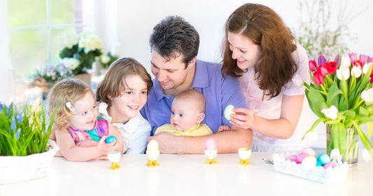 Family Easter traditions: parents and kids playing with Easter treats and eggs during a holiday morning at home.