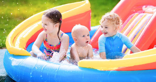 Children playing in an inflatable pool in the backyard, enjoying outdoor water fun on a sunny summer day.