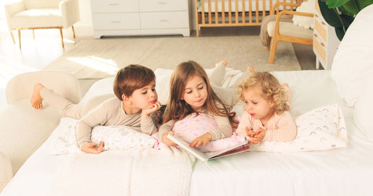 Toddlers bonding on a cozy bed, feeling comfortable while resting with a soft toddler pillow.