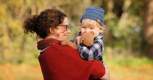 Mom and toddler sharing a candid moment during a cozy fall photoshoot at home