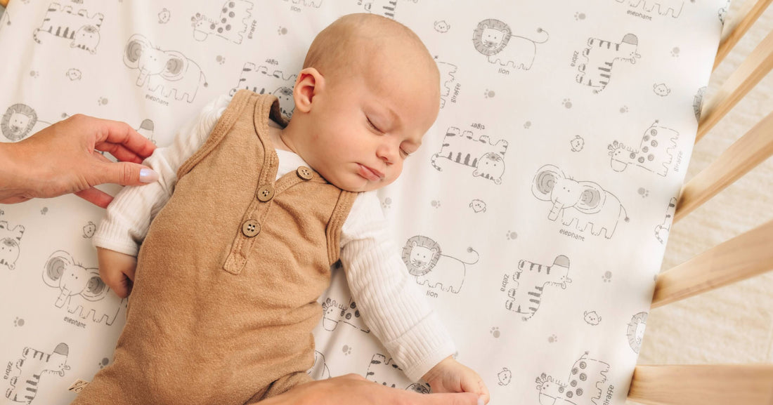 Baby wearing cozy fall-colored clothing on a soft KeaBabies crib sheet, creating a warm and comfortable autumn sleep environment.