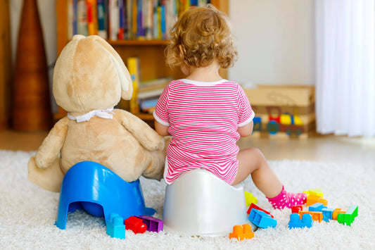 Baby enjoying potty training while playing with toys, promoting a fun and stress-free potty training experience for toddlers.