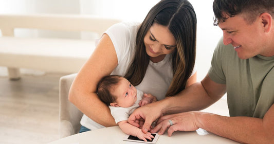 Mom and Dad creating a precious baby keepsake using an inkless ink pad – a perfect way to cherish family bonding moments. Ideal for Valentine’s Day memories and baby handprint crafts.