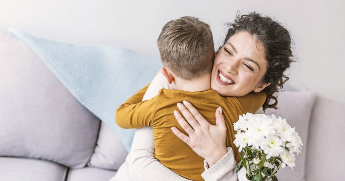 Mom joyfully hugging her toddler as they gift her a bouquet of flowers – heartwarming parent-child moment.