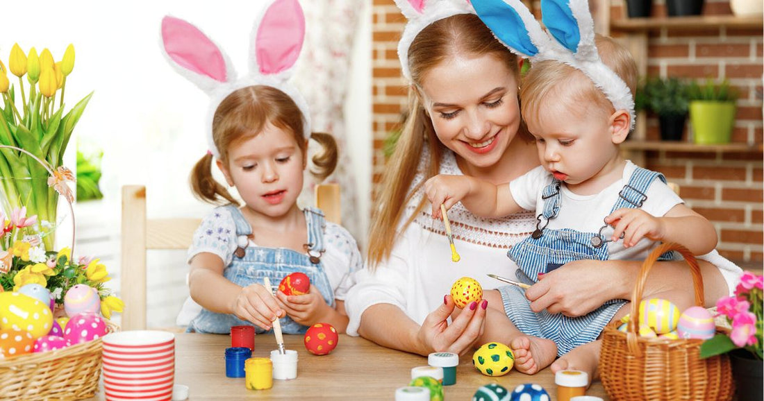 Family Easter activity – mom and kids painting colorful eggs for the holiday.