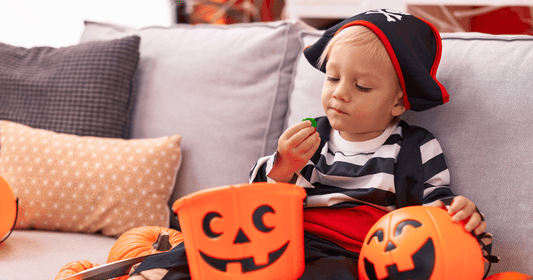 A young boy in a pirate costume enjoying healthy snacks during a Halloween celebration