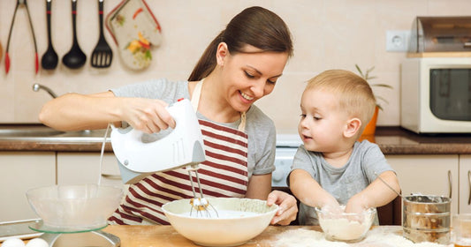 Mom and baby sharing a joyful moment while preparing Christmas meals together.