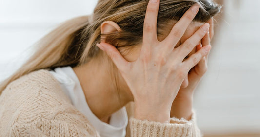 Exhausted and frustrated mom holding her head – mental load of motherhood and parenting stress