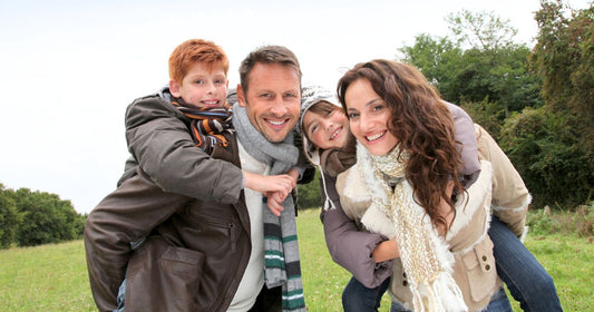 Parents doing piggyback to their children in countryside