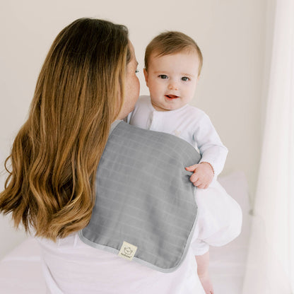 Parent holding a baby with a gray muslin burp cloth placed over the shoulder for catching spit-ups during burping. 26488005886138